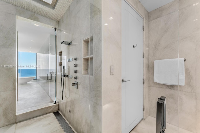 bathroom with a shower stall and tile walls