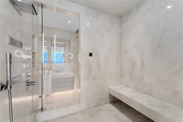 bathroom with a stall shower, tile patterned flooring, tile walls, and vanity