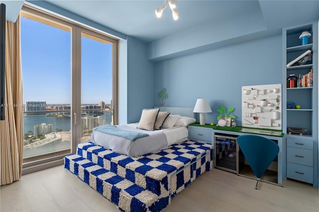 bedroom featuring wine cooler and a water view