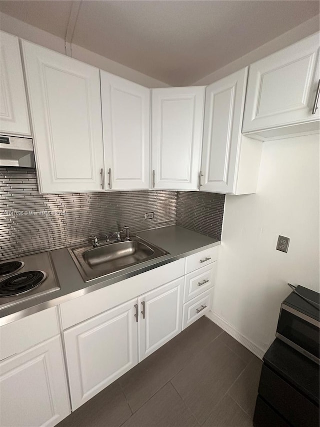 kitchen featuring decorative backsplash, white cabinets, ventilation hood, stainless steel electric cooktop, and a sink