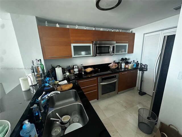 kitchen featuring dark countertops, modern cabinets, and appliances with stainless steel finishes
