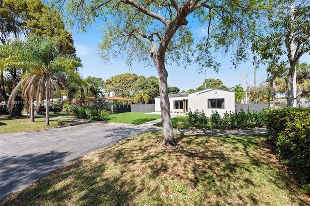 view of front facade with fence, a front lawn, and stucco siding