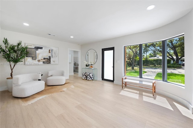 sitting room featuring light wood-type flooring, visible vents, baseboards, and recessed lighting