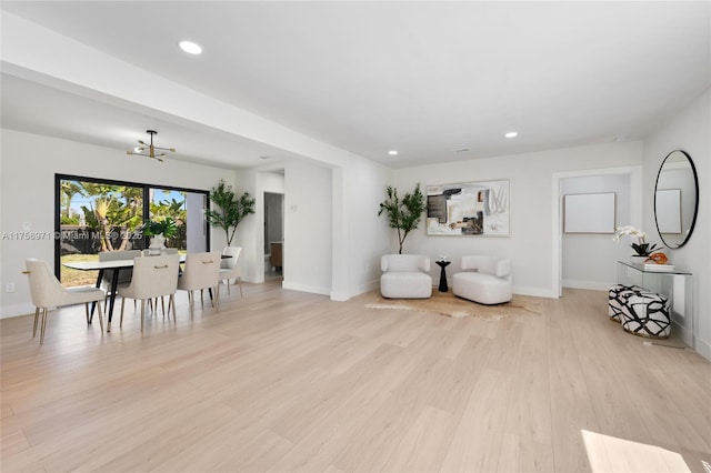 living area with light wood-type flooring, baseboards, and recessed lighting