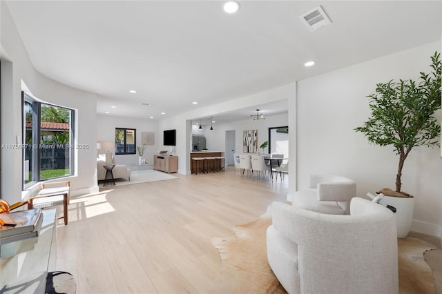 living room with light wood-style floors, baseboards, visible vents, and recessed lighting