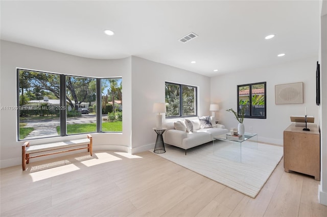 living room with baseboards, recessed lighting, visible vents, and light wood-style floors