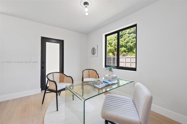 dining area with light wood-style flooring and baseboards