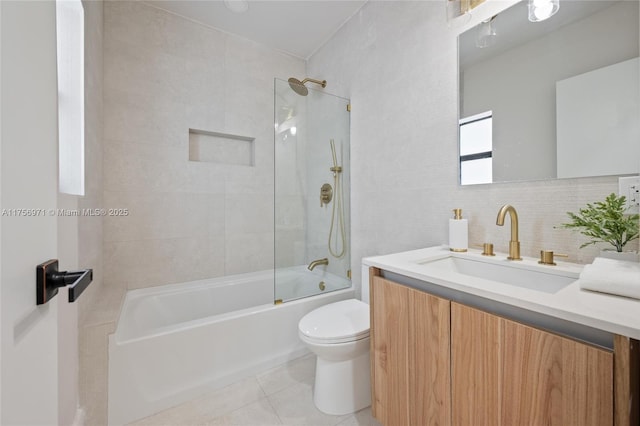 full bathroom with tile walls, shower / bathing tub combination, toilet, vanity, and tile patterned flooring