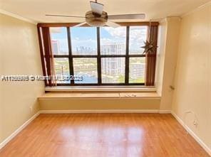 empty room featuring ornamental molding, light wood-type flooring, and a healthy amount of sunlight