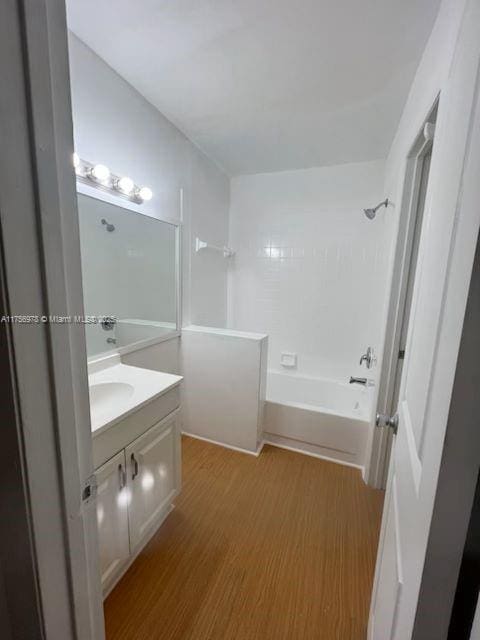 full bathroom with bathing tub / shower combination, wood finished floors, and vanity