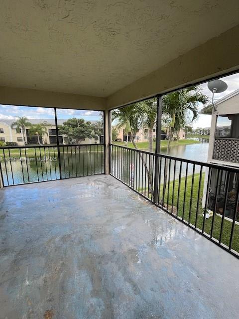 unfurnished sunroom featuring a water view