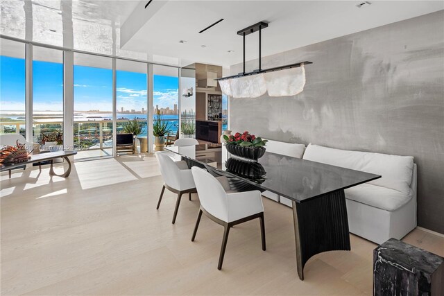 dining space with breakfast area, expansive windows, and light wood finished floors