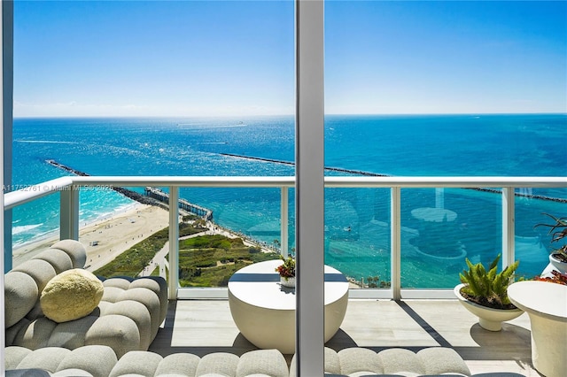 balcony featuring a beach view and a water view