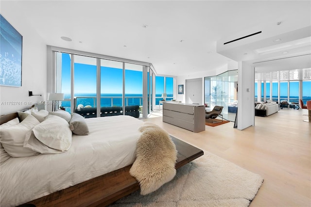 100 S Pointe Dr Unit 2803, Miami Beach, FL 33139 - bedroom featuring a wall of windows, light wood-style floors, and a water view