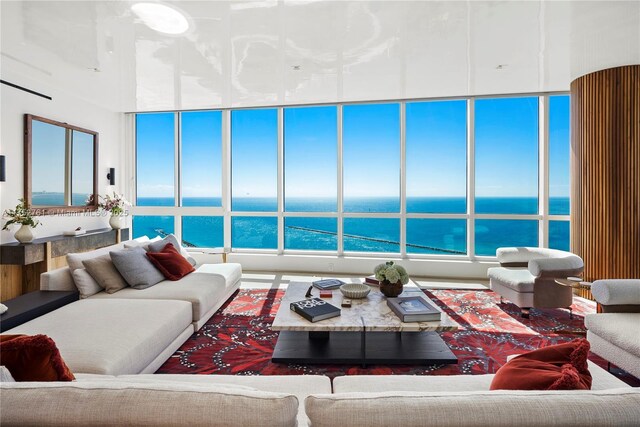 living room with a water view and a high ceiling