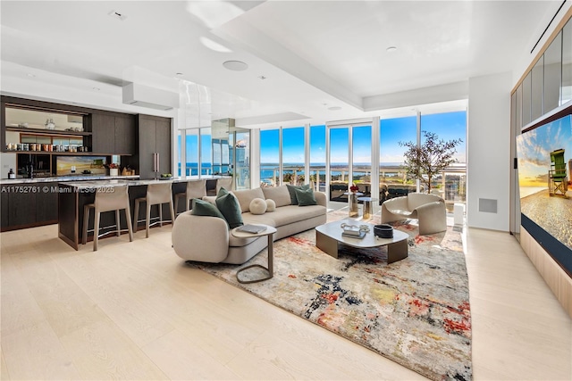 living area with light wood-type flooring and floor to ceiling windows