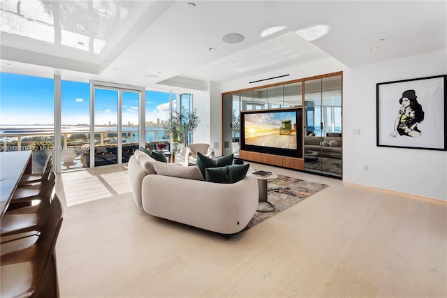 living area with a wall of windows and wood finished floors