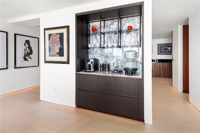 bar featuring light wood-style flooring and baseboards