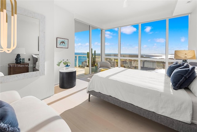 100 S Pointe Dr Unit 2803, Miami Beach, FL 33139 - bedroom featuring a water view, floor to ceiling windows, access to exterior, and wood finished floors