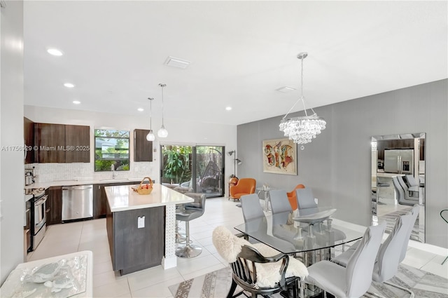 dining area with recessed lighting, a notable chandelier, and light tile patterned floors