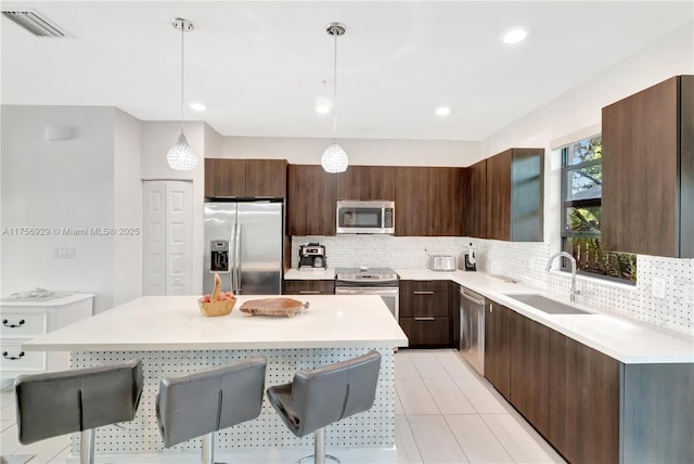 kitchen featuring stainless steel appliances, backsplash, a sink, and light countertops