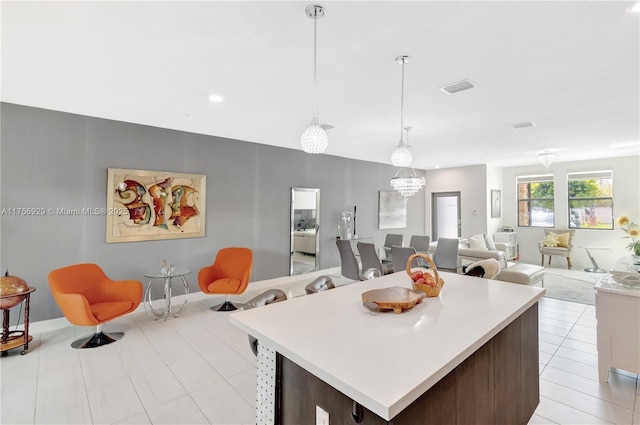 kitchen featuring light countertops, open floor plan, visible vents, and decorative light fixtures