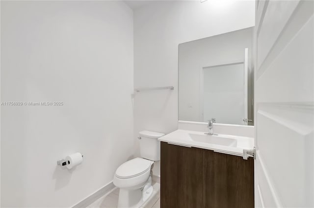 half bath with baseboards, vanity, toilet, and tile patterned floors