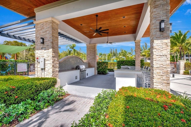 view of patio with ceiling fan, area for grilling, fence, and a pergola