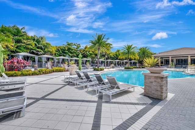 community pool featuring fence and a patio