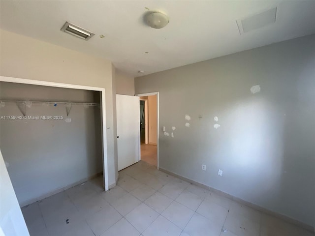 unfurnished bedroom with a closet, visible vents, and baseboards