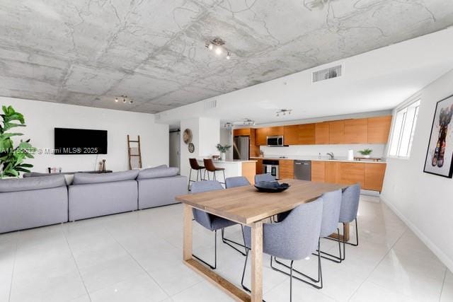 dining area featuring light tile patterned floors, baseboards, and visible vents