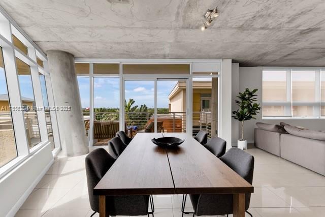 dining area with a wall of windows and light tile patterned floors