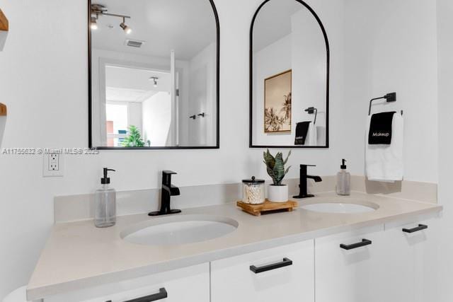 full bathroom featuring visible vents, a sink, and double vanity