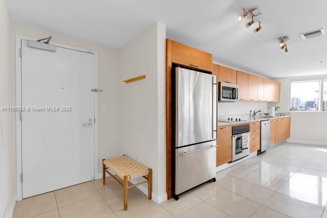 kitchen featuring visible vents, appliances with stainless steel finishes, light countertops, a sink, and light tile patterned flooring