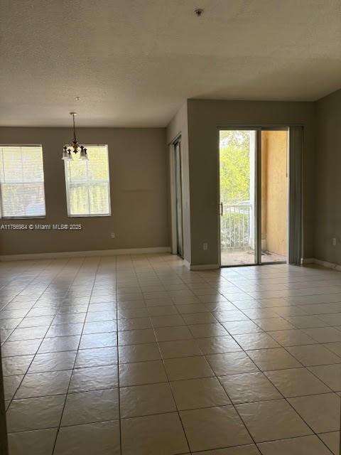2111 Shoma Dr Unit 2111, Royal Palm Beach, FL 33414 - tiled empty room with healthy amount of natural light and a chandelier