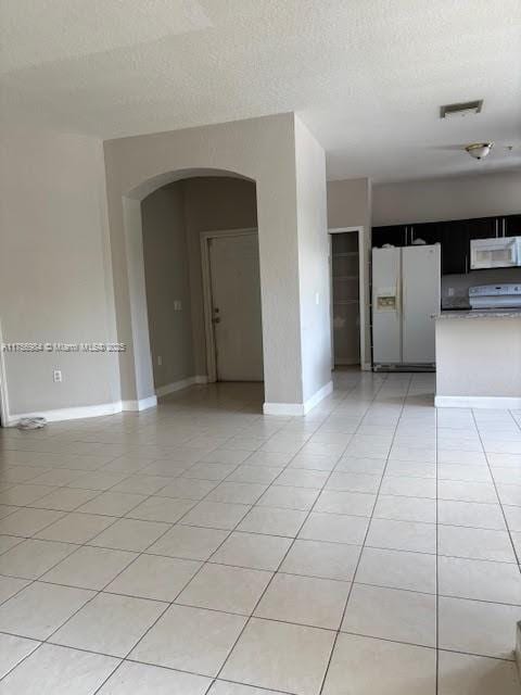 2111 Shoma Dr Unit 2111, Royal Palm Beach, FL 33414 - empty room with arched walkways, light tile patterned floors, and a textured ceiling