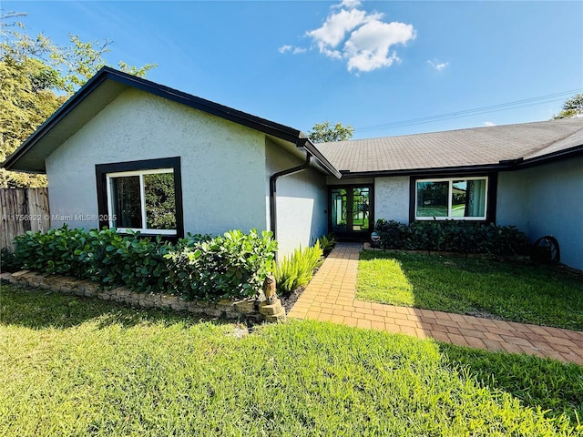 single story home featuring a front lawn, fence, and stucco siding