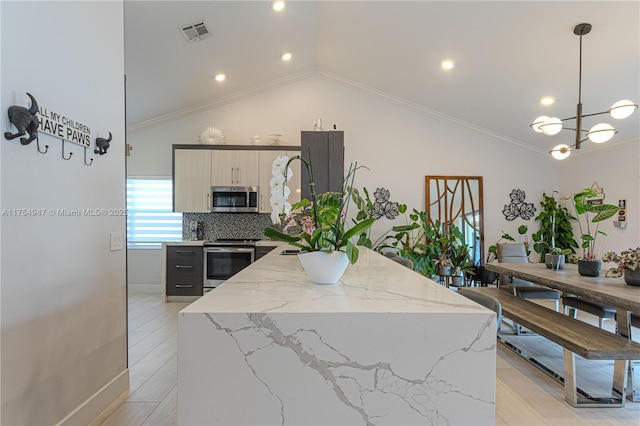 kitchen with ornamental molding, hanging light fixtures, appliances with stainless steel finishes, and visible vents