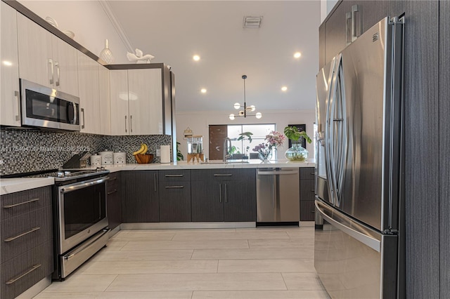 kitchen with light countertops, appliances with stainless steel finishes, a sink, and crown molding