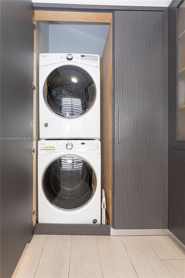 washroom with stacked washer / drying machine and laundry area