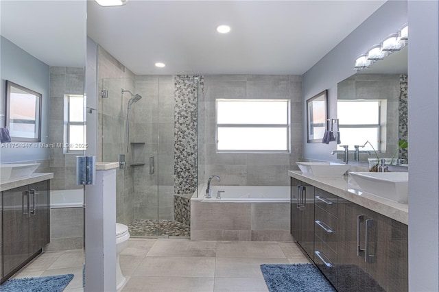 full bathroom featuring a garden tub, double vanity, a stall shower, and a sink