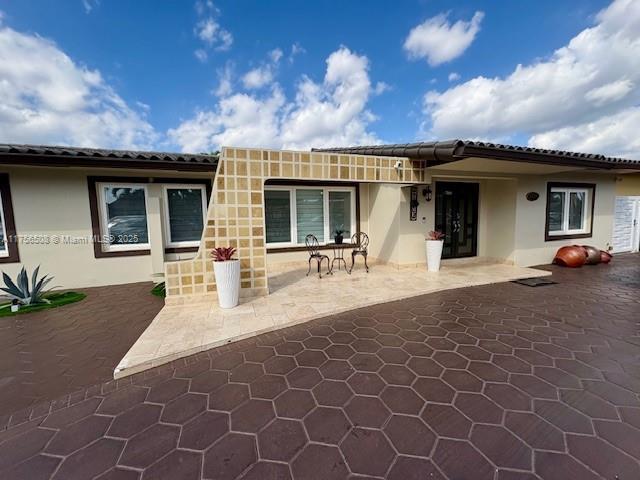 rear view of house featuring a patio and stucco siding