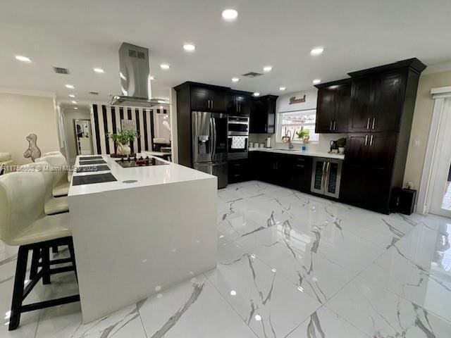 kitchen featuring recessed lighting, refrigerator with ice dispenser, marble finish floor, light countertops, and island exhaust hood