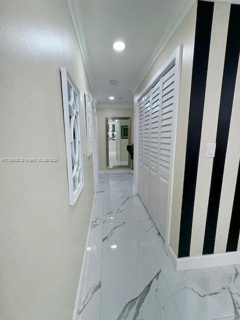 hallway with marble finish floor, baseboards, ornamental molding, and recessed lighting