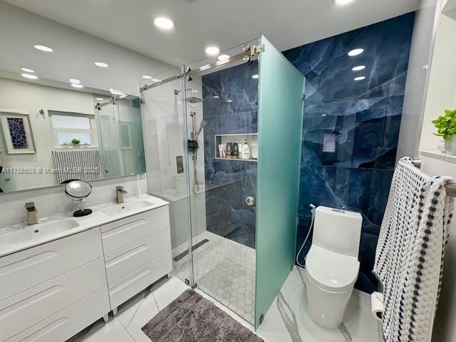 full bath featuring a stall shower, a sink, tile walls, and toilet