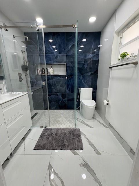 bathroom with a stall shower, marble finish floor, vanity, and toilet