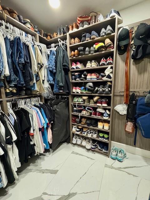 spacious closet featuring marble finish floor