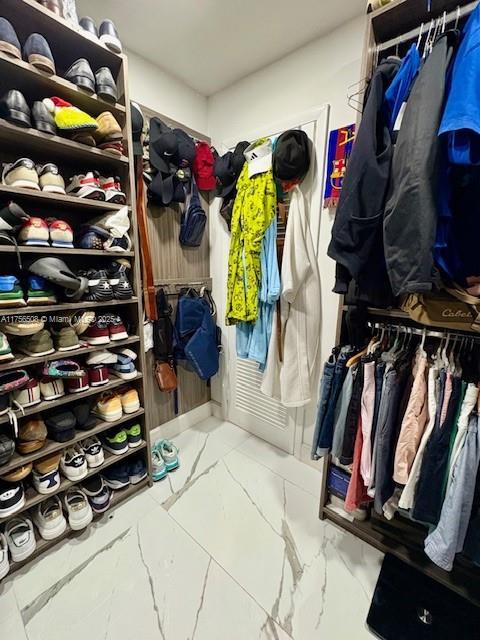 spacious closet featuring marble finish floor