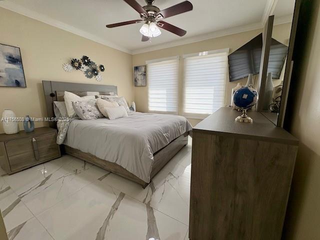 bedroom with marble finish floor, ceiling fan, and ornamental molding