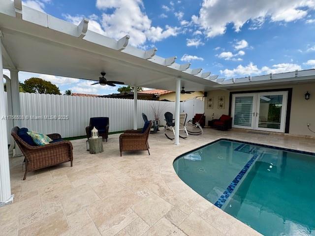 view of pool featuring a ceiling fan, french doors, and fence